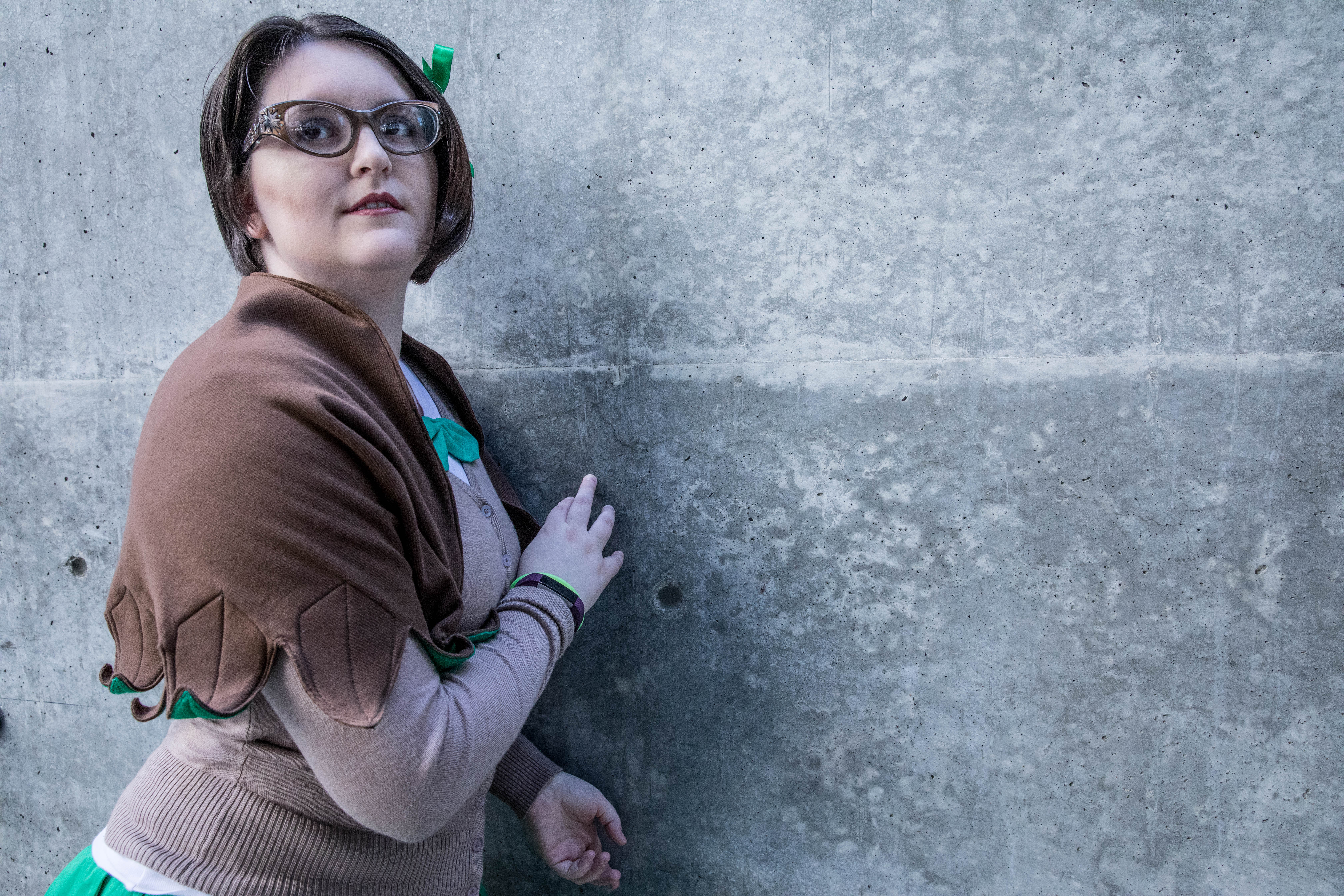 Rowlet schoolgirl posing against a grey wall.