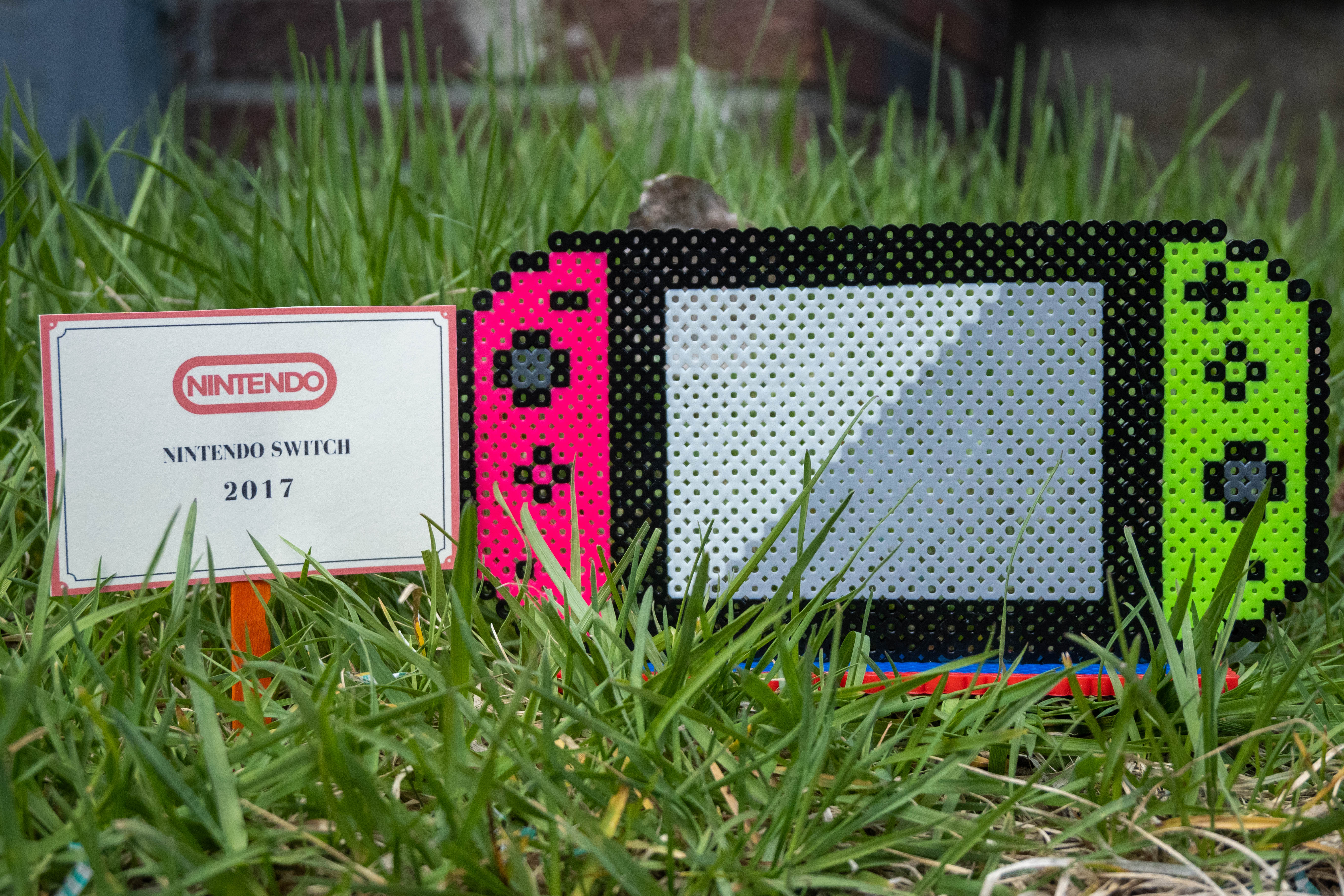 Nintendo Switch console with pink and green joycons made out of Perler brand fuse beads.