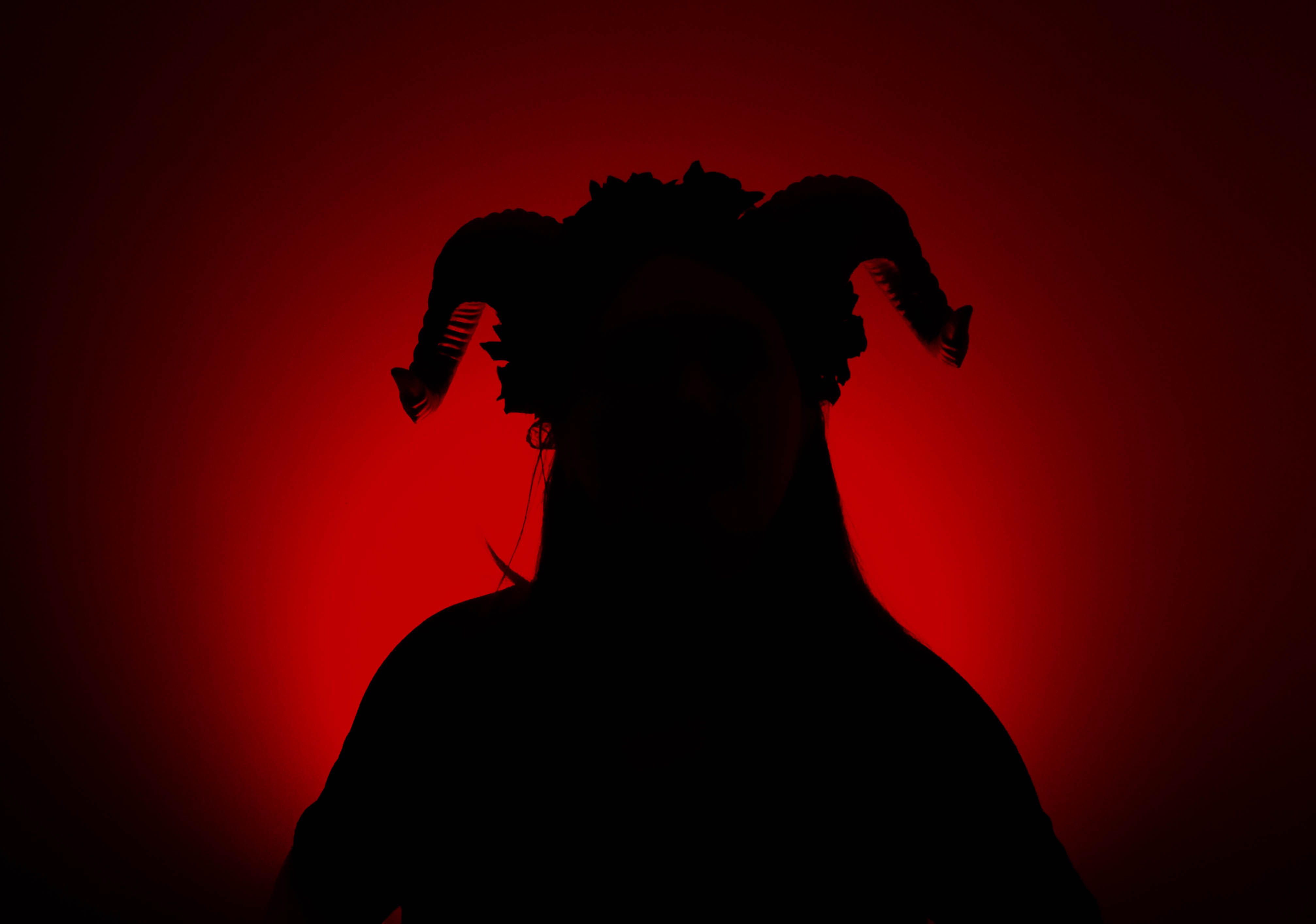 Shadow with horns against a red light background.